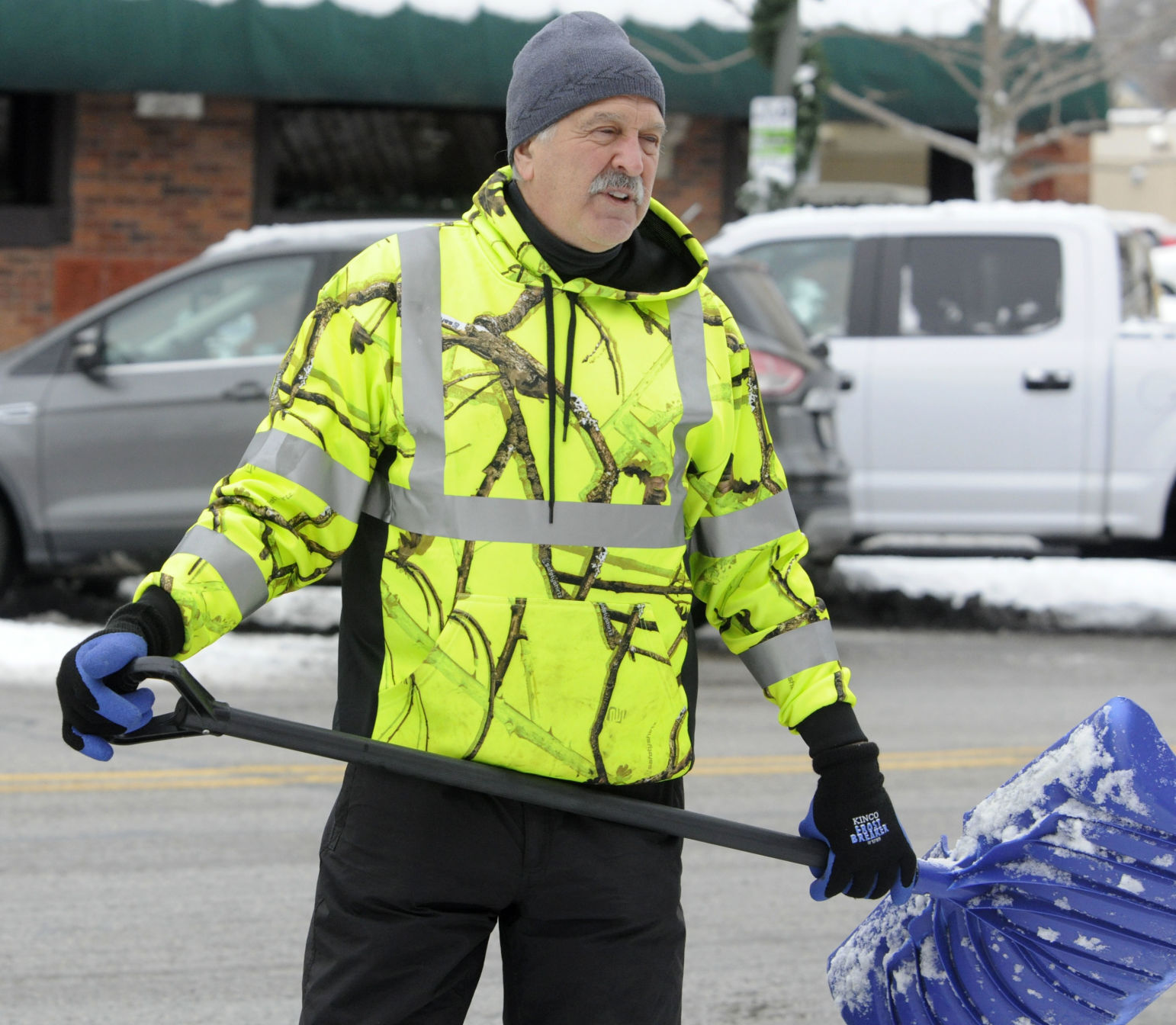 Louie Chironis, co-owner of Hogs & Kisses Dance & Night Club, helps to shovel snow on Broad Street in downtown Lake Geneva